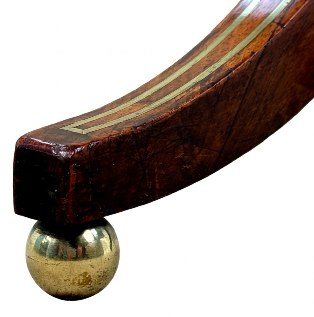 A nineteenth-century Regency rosewood occasional table featuring a rectangular top with rounded corners, fine brass inlay stringing, a turned central column, and a tripod base resting on brass feet. View IV