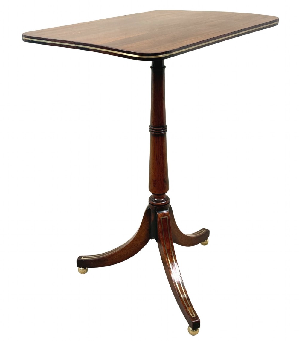 A nineteenth-century Regency rosewood occasional table featuring a rectangular top with rounded corners, fine brass inlay stringing, a turned central column, and a tripod base resting on brass feet. View VI