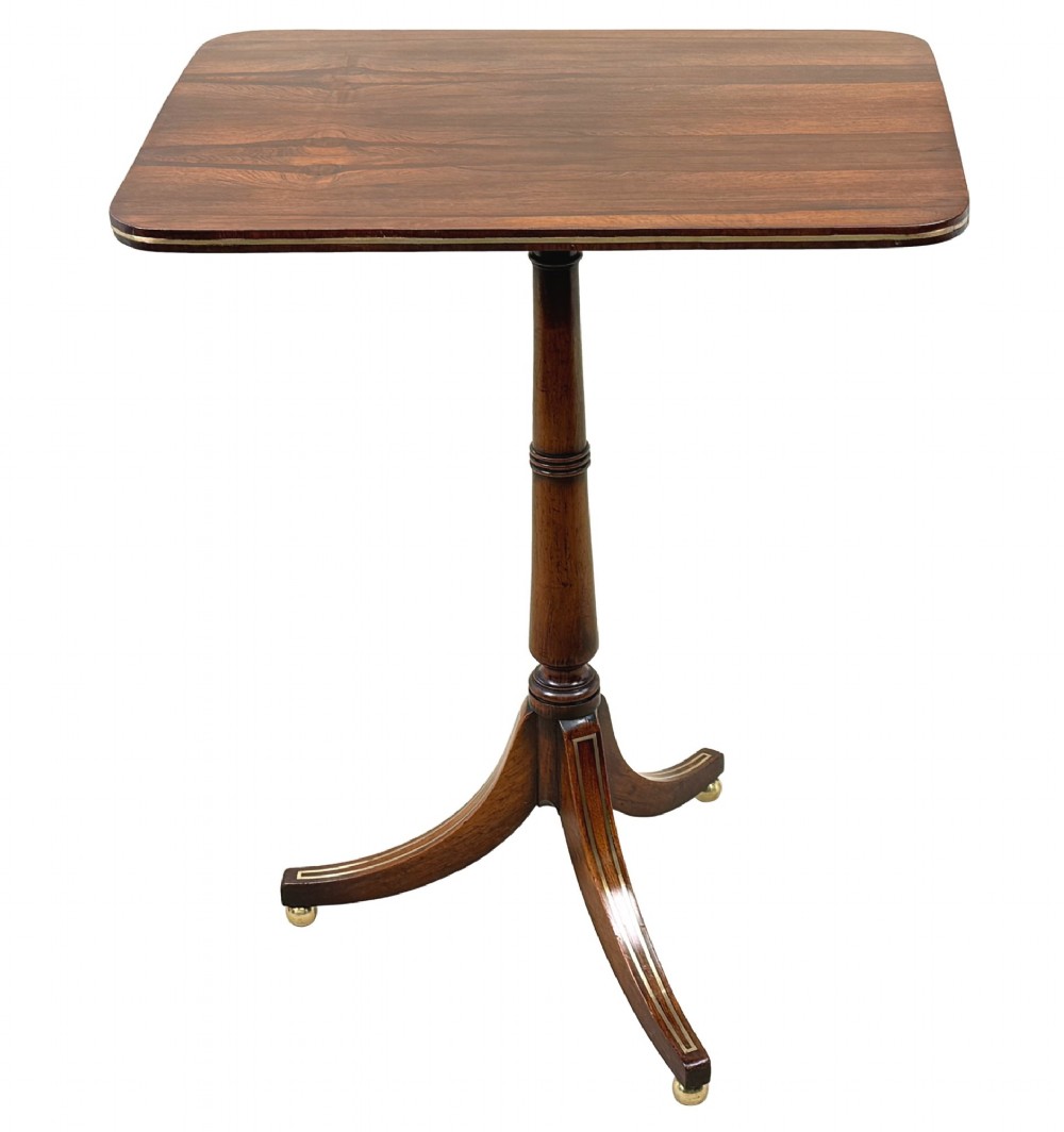 A nineteenth-century Regency rosewood occasional table featuring a rectangular top with rounded corners, fine brass inlay stringing, a turned central column, and a tripod base resting on brass feet. View XII