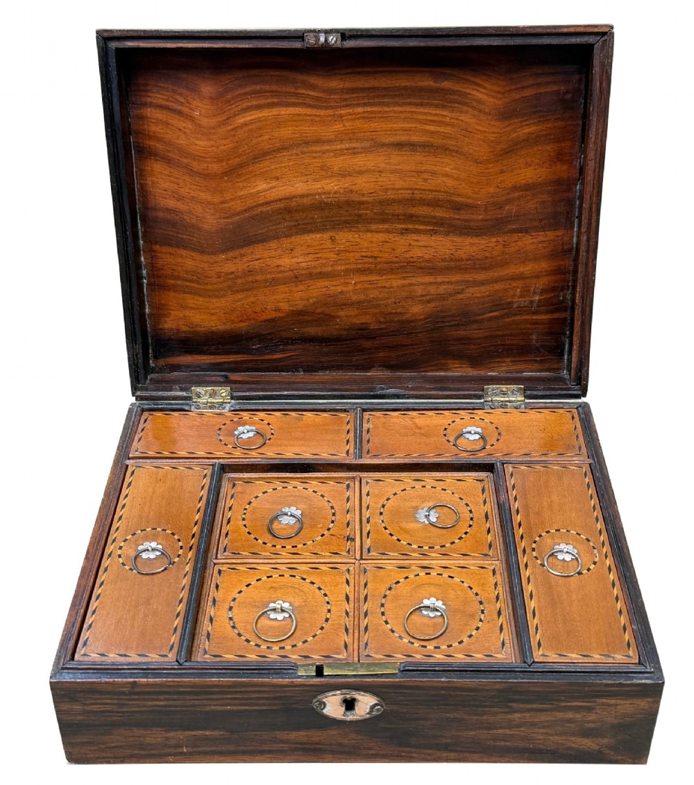 A 19th-century rectangular coromandel wood work box featuring a hinged lid, rich striped graining, and a central escutcheon. View V