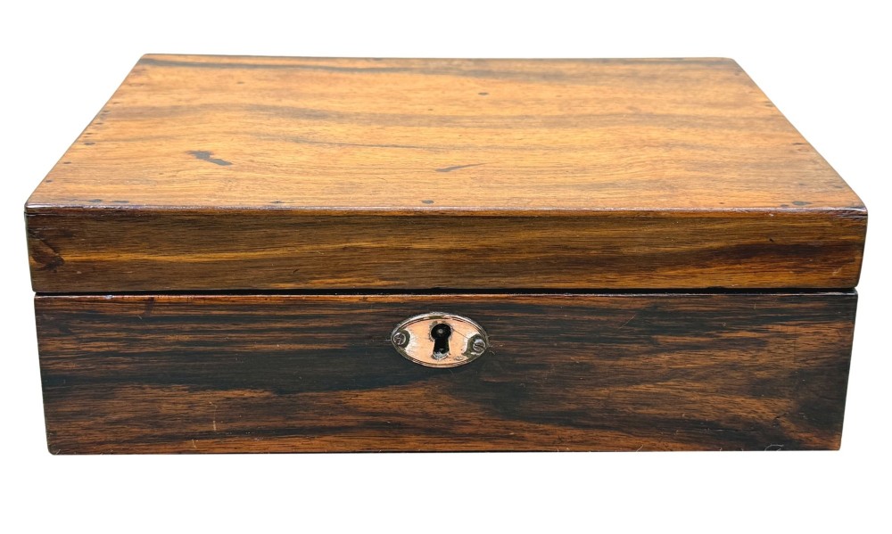 A 19th-century rectangular coromandel wood work box featuring a hinged lid, rich striped graining, and a central escutcheon. View X
