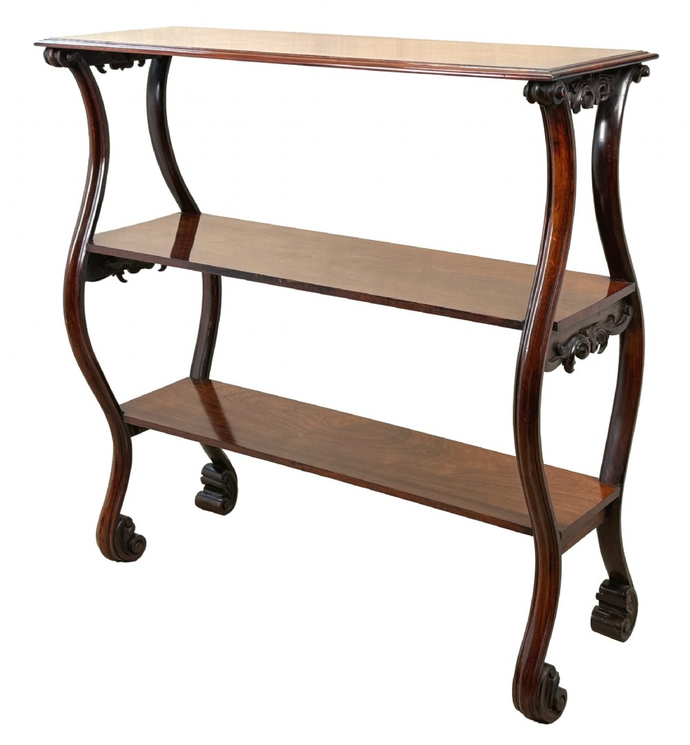 A mid-19th century three-tier rosewood standing buffet unit featuring curved leg supports and carved scroll details.