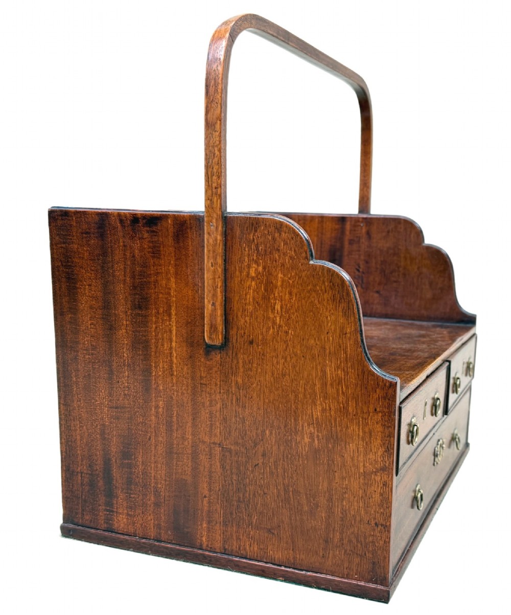 An 18th-century Georgian mahogany book carrier featuring a curved wooden top handle, a rear wire mesh panel, shaped side galleries, and three small drawers fitted with brass drop ring handles. View II
