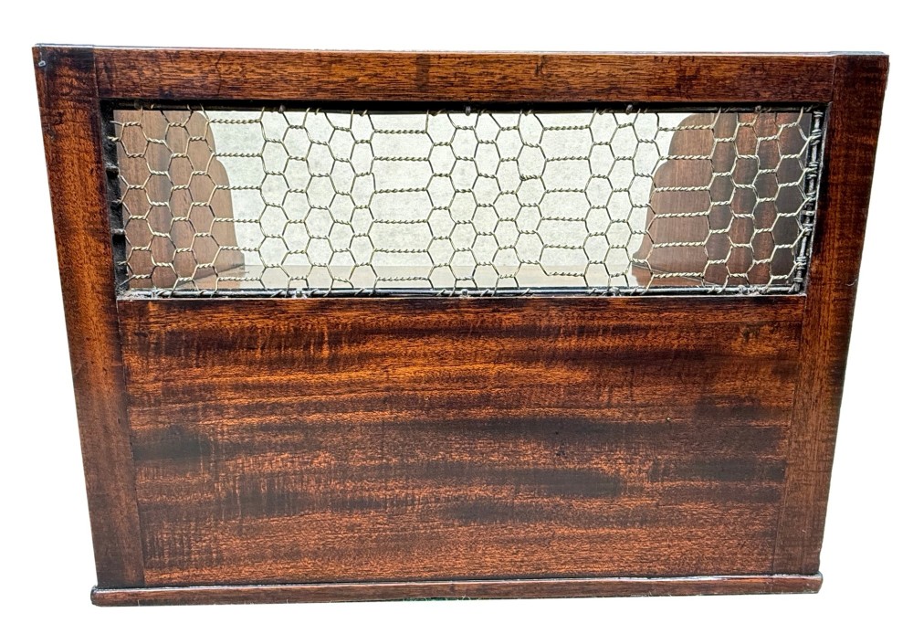 An 18th-century Georgian mahogany book carrier featuring a curved wooden top handle, a rear wire mesh panel, shaped side galleries, and three small drawers fitted with brass drop ring handles. View X