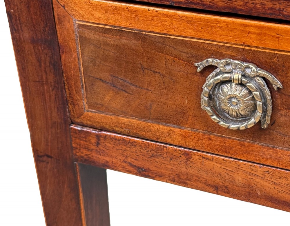 An 18th-century Georgian mahogany patience table featuring a folding top, brass corner brackets, a single drawer with ring handles, and square tapered legs. View X