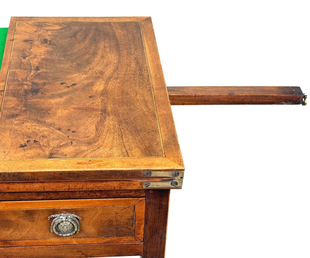 An 18th-century Georgian mahogany patience table featuring a folding top, brass corner brackets, a single drawer with ring handles, and square tapered legs. View XI