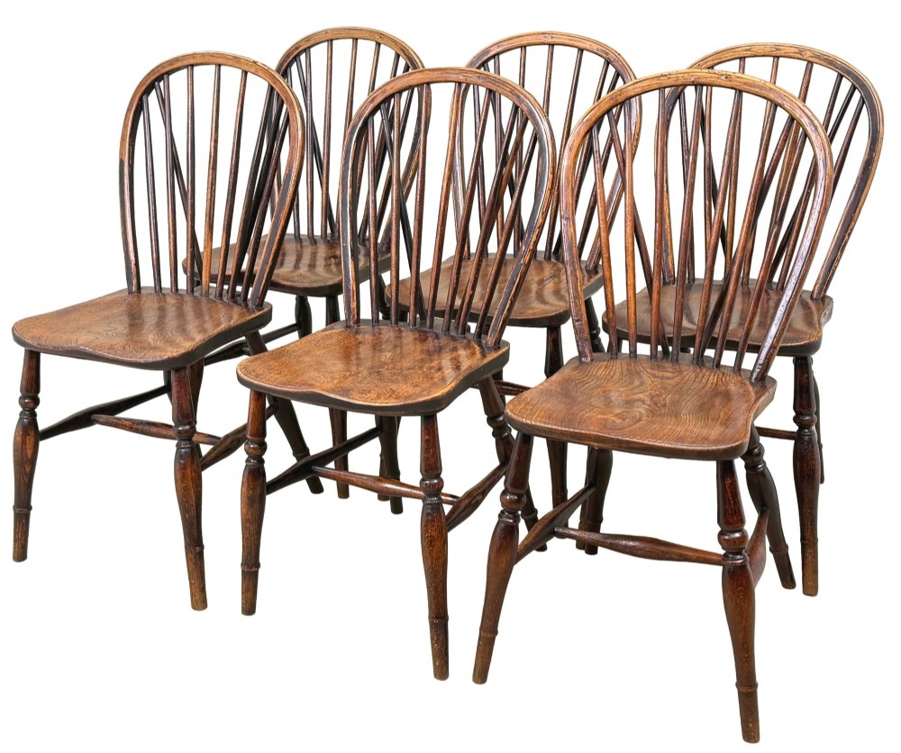 A set of six 19th-century dark wooden farmhouse dining chairs featuring hoop backs with vertical spindles and turned legs.