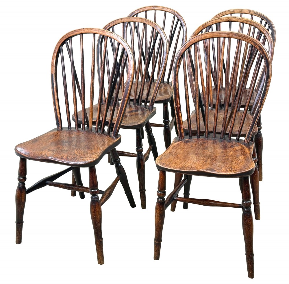 A set of six 19th-century dark wooden farmhouse dining chairs featuring hoop backs with vertical spindles and turned legs. View V