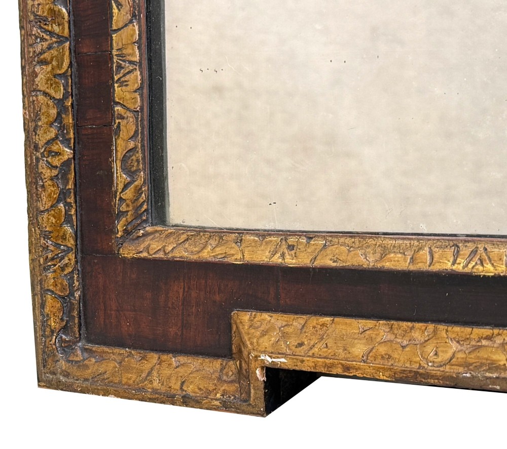 An early 18th-century rectangular wall mirror featuring a dark walnut frame bordered with gilded leaf mouldings and stepped projecting corners. View IV