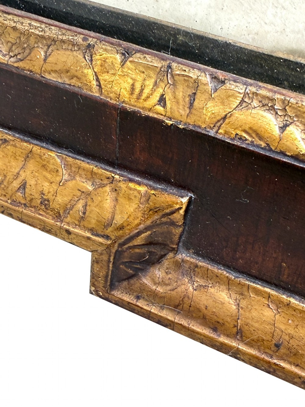 An early 18th-century rectangular wall mirror featuring a dark walnut frame bordered with gilded leaf mouldings and stepped projecting corners. View VIII