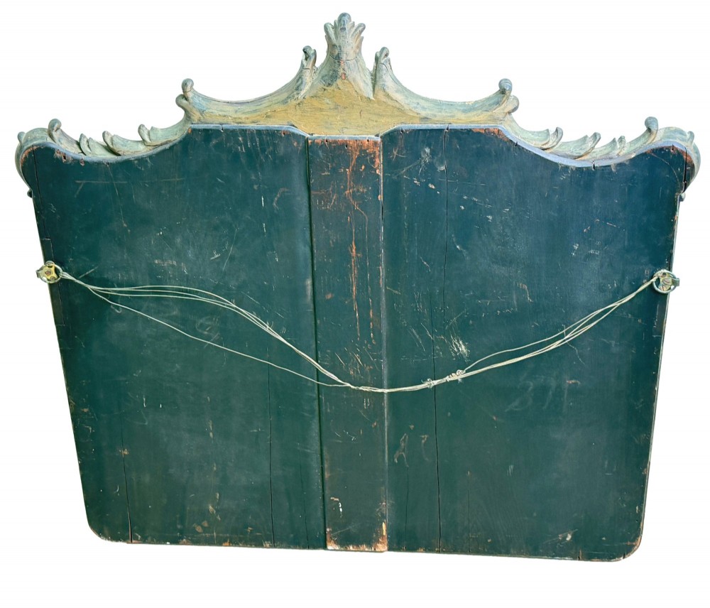 A late 19th-century giltwood wall mirror featuring a carved gesso cresting with scrollwork and dripping fringe details above a rectangular glass panel. View VIII