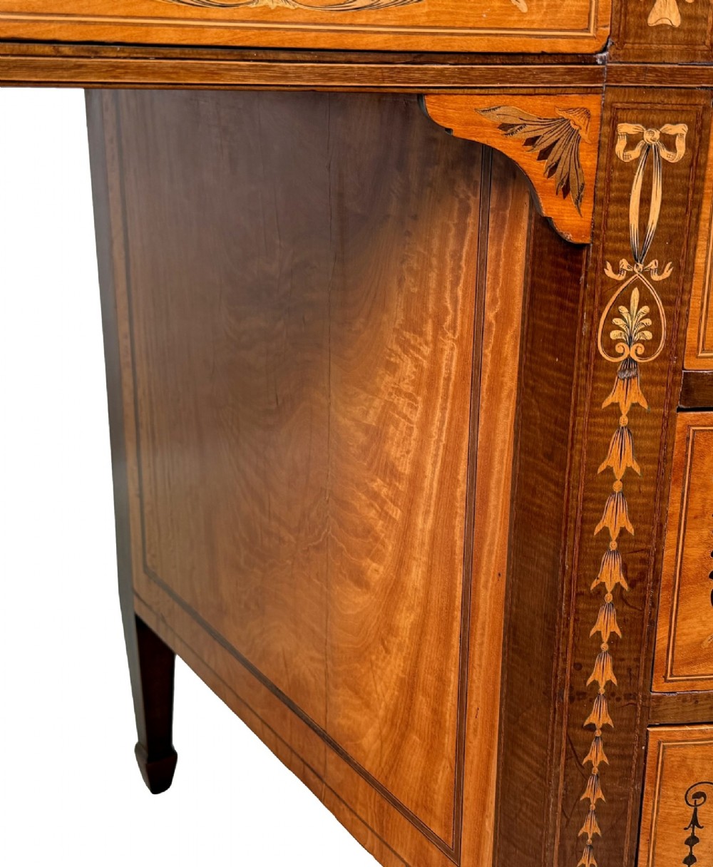 A late nineteenth-century kidney-shaped satinwood writing desk with detailed floral marquetry inlays, twin pedestals, and a leather insert top. View XI