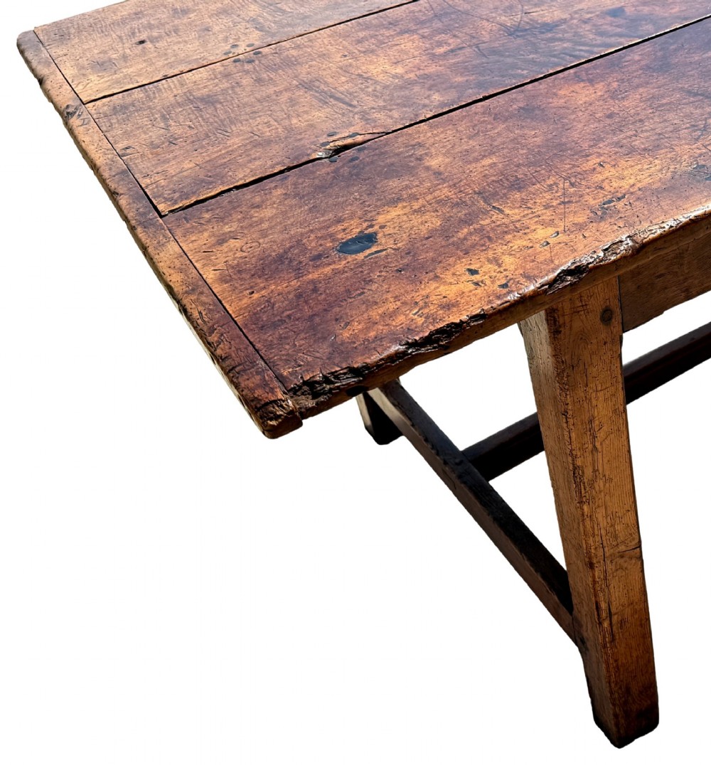 An 18th-century English farmhouse dining table crafted from warm brown oak with a wide three-plank top, plain apron, and an H-stretcher base. View IV