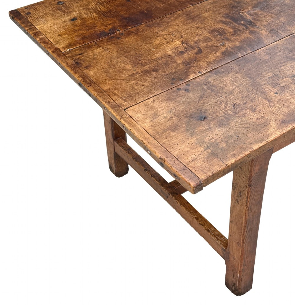 An 18th-century English farmhouse dining table crafted from warm brown oak with a wide three-plank top, plain apron, and an H-stretcher base. View VI