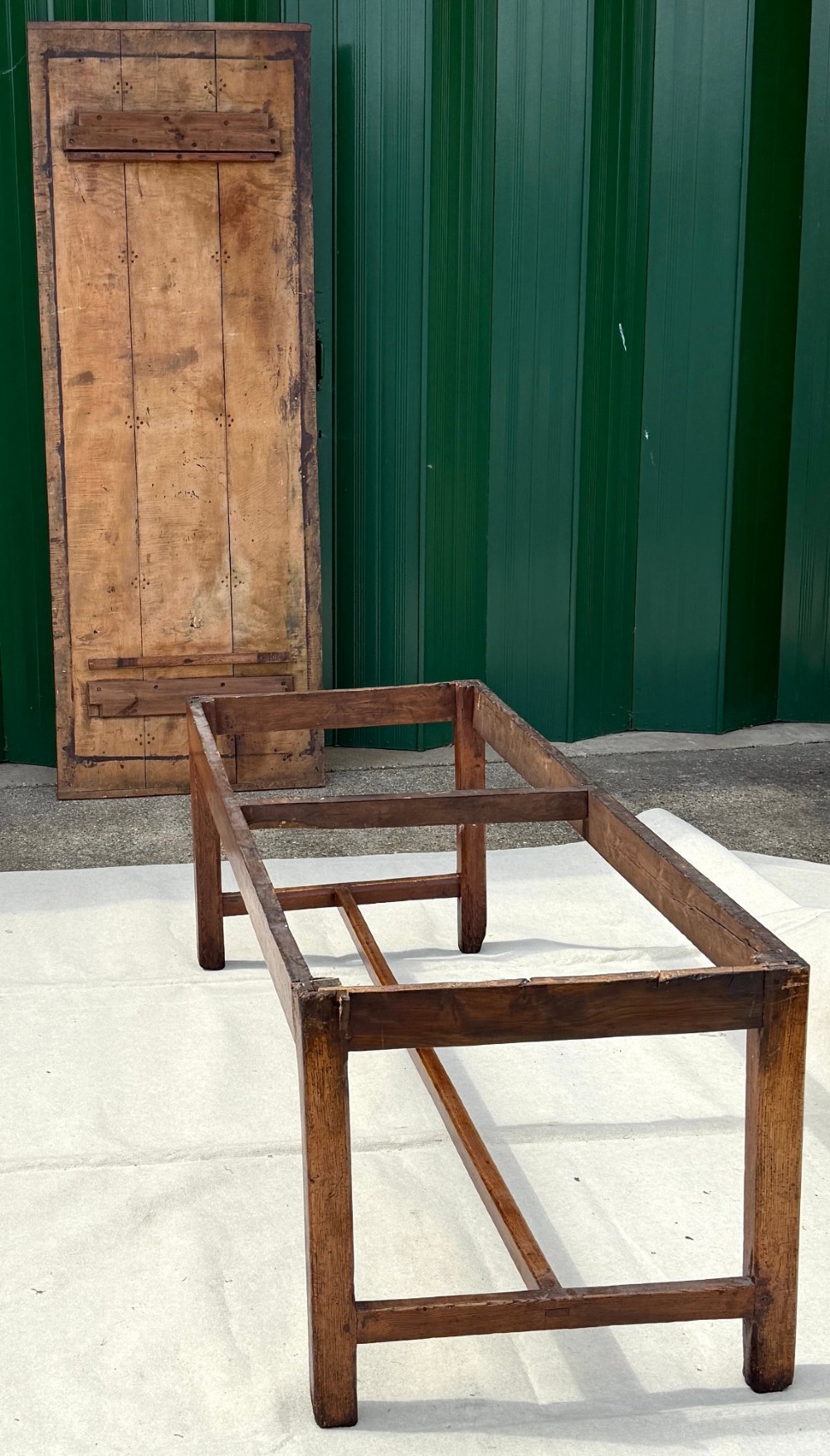 An 18th-century English farmhouse dining table crafted from warm brown oak with a wide three-plank top, plain apron, and an H-stretcher base. View XI