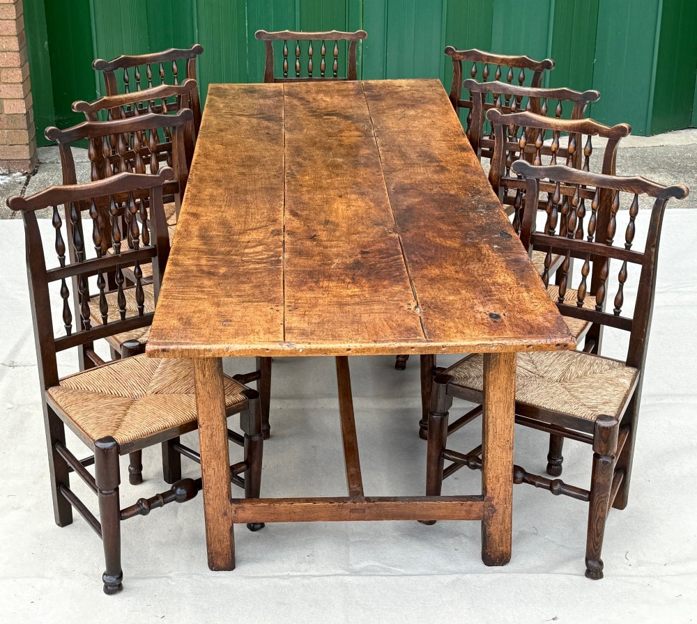 An 18th-century English farmhouse dining table crafted from warm brown oak with a wide three-plank top, plain apron, and an H-stretcher base. View XIII