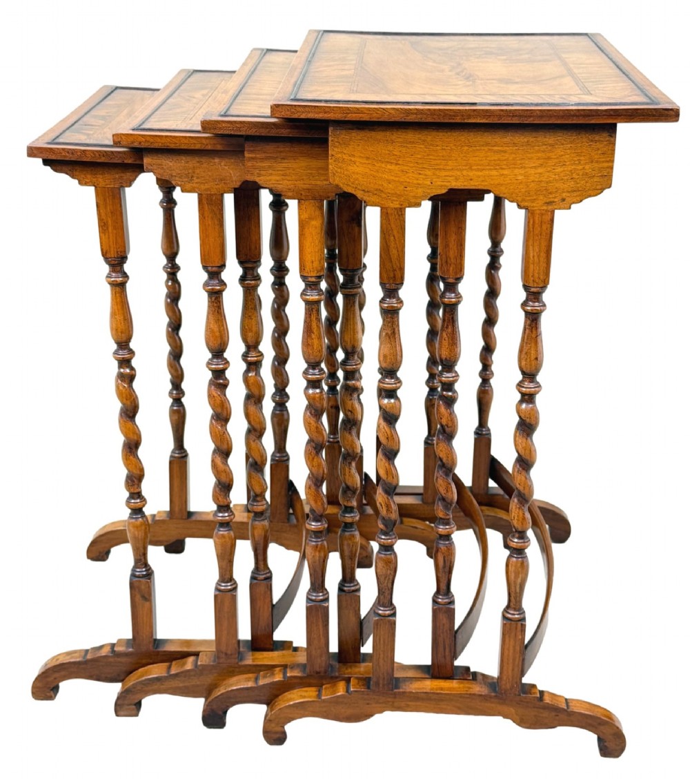 A set of four early twentieth-century brown walnut nesting tables featuring barley twist legs, arched stretchers, and banded inlaid tops stacked in graduated size. View III