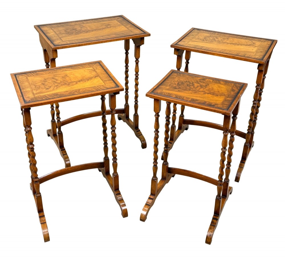 A set of four early twentieth-century brown walnut nesting tables featuring barley twist legs, arched stretchers, and banded inlaid tops stacked in graduated size. View IV