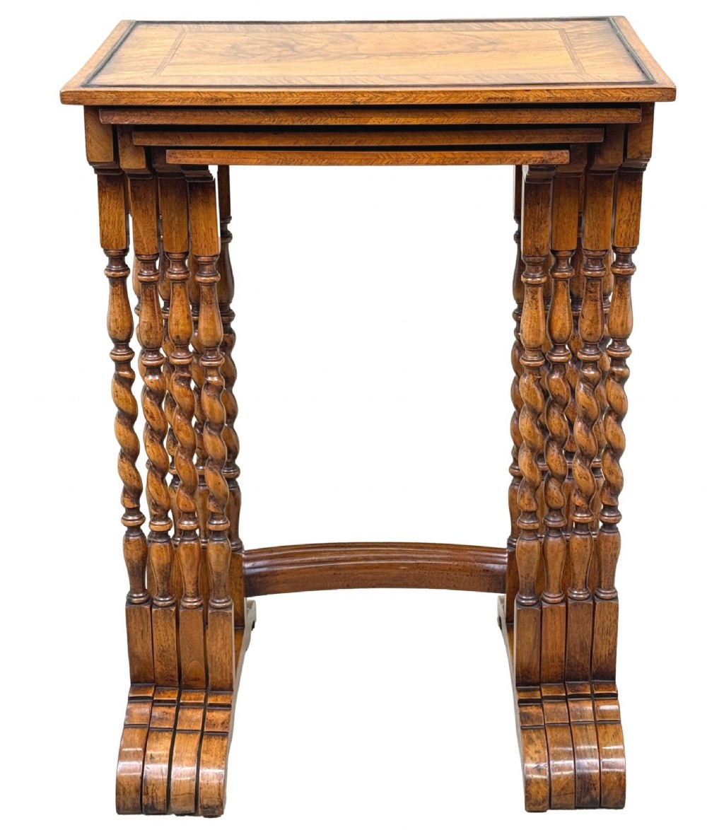 A set of four early twentieth-century brown walnut nesting tables featuring barley twist legs, arched stretchers, and banded inlaid tops stacked in graduated size. View VII