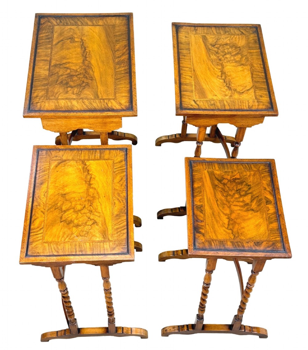A set of four early twentieth-century brown walnut nesting tables featuring barley twist legs, arched stretchers, and banded inlaid tops stacked in graduated size. View VIII