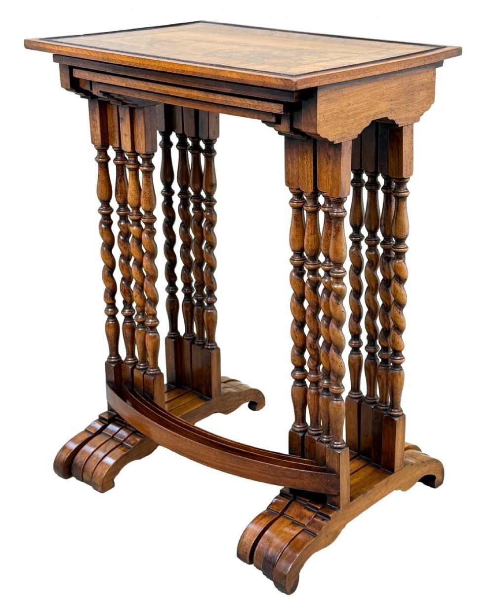 A set of four early twentieth-century brown walnut nesting tables featuring barley twist legs, arched stretchers, and banded inlaid tops stacked in graduated size. View XII