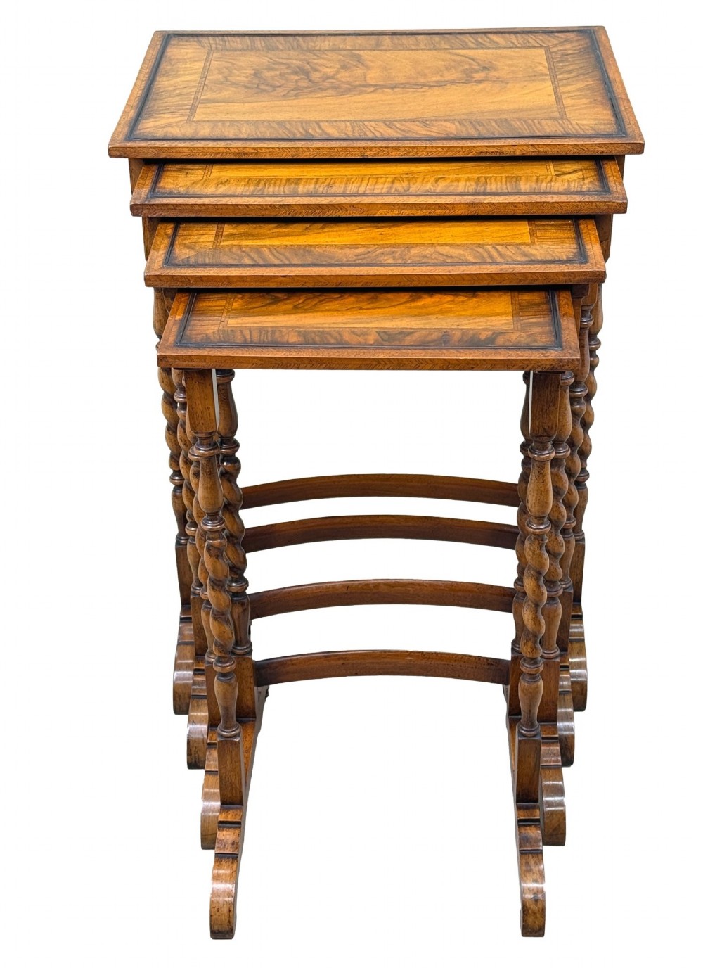 A set of four early twentieth-century brown walnut nesting tables featuring barley twist legs, arched stretchers, and banded inlaid tops stacked in graduated size. View XIII