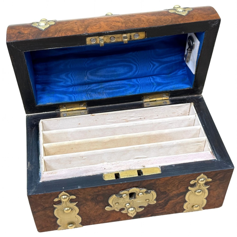 A nineteenth-century domed stationery box crafted from highly figured burr walnut with ornamental brass strapwork and studs. View VII