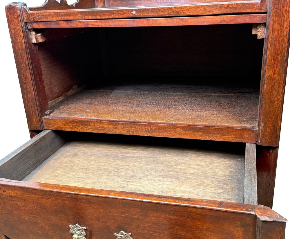 A matched pair of 18th-century Georgian mahogany bedside tables featuring scalloped tray top galleries, brass hardware, and shaped aprons. View V