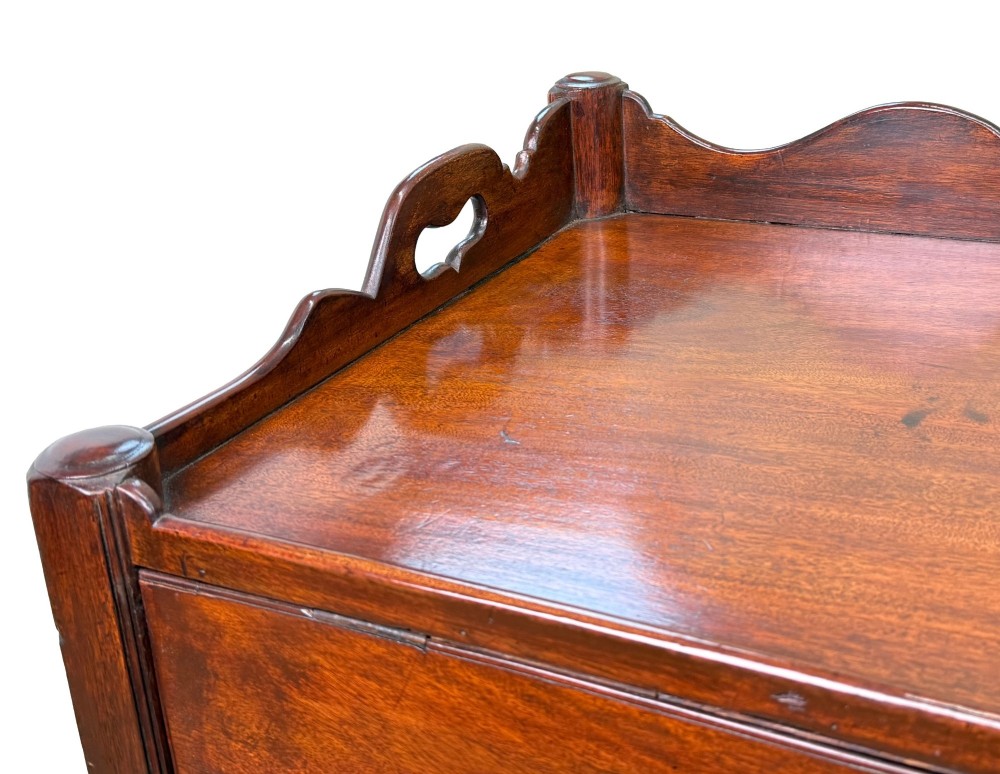 A matched pair of 18th-century Georgian mahogany bedside tables featuring scalloped tray top galleries, brass hardware, and shaped aprons. View VI
