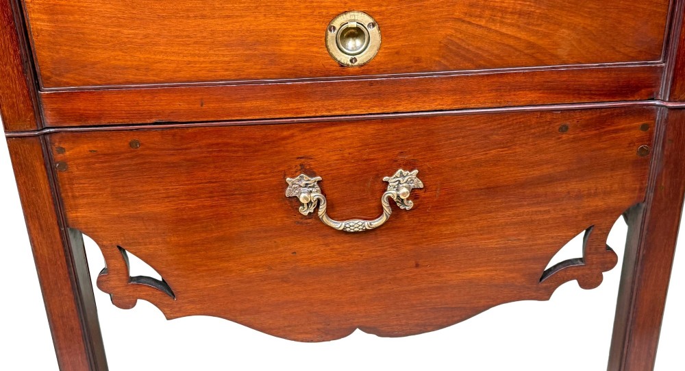 A matched pair of 18th-century Georgian mahogany bedside tables featuring scalloped tray top galleries, brass hardware, and shaped aprons. View VII