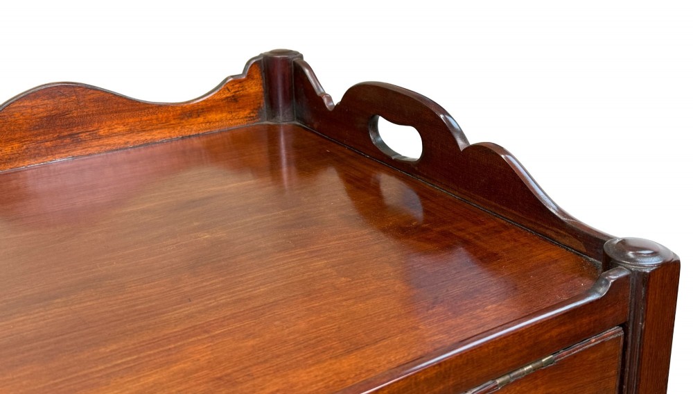 A matched pair of 18th-century Georgian mahogany bedside tables featuring scalloped tray top galleries, brass hardware, and shaped aprons. View VIII