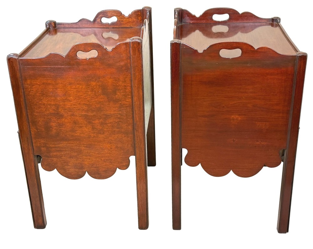 A matched pair of 18th-century Georgian mahogany bedside tables featuring scalloped tray top galleries, brass hardware, and shaped aprons. View X