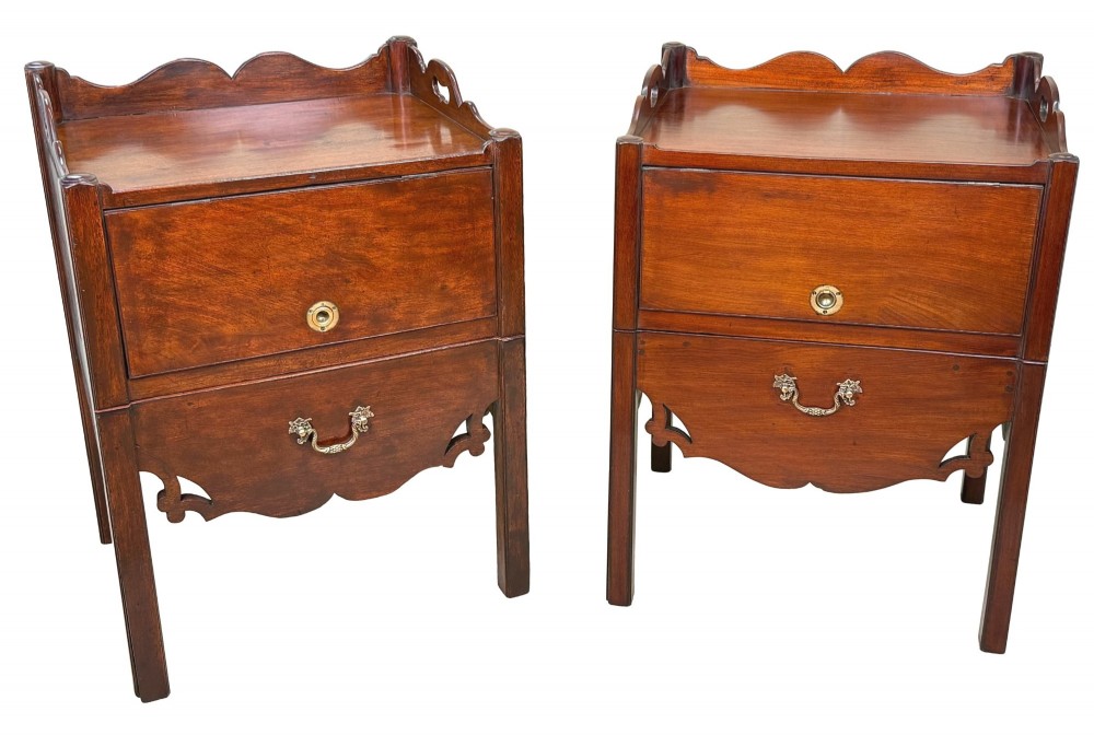 A matched pair of 18th-century Georgian mahogany bedside tables featuring scalloped tray top galleries, brass hardware, and shaped aprons. View XII