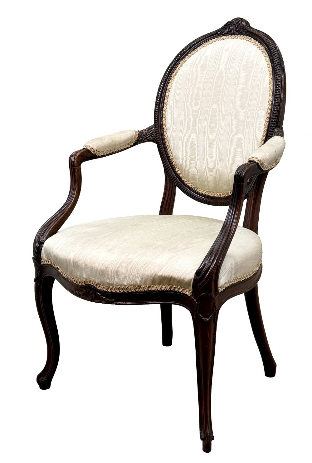 An 18th-century Georgian mahogany salon chair featuring an oval back rest, carved wooden frame, and cream silk upholstery.