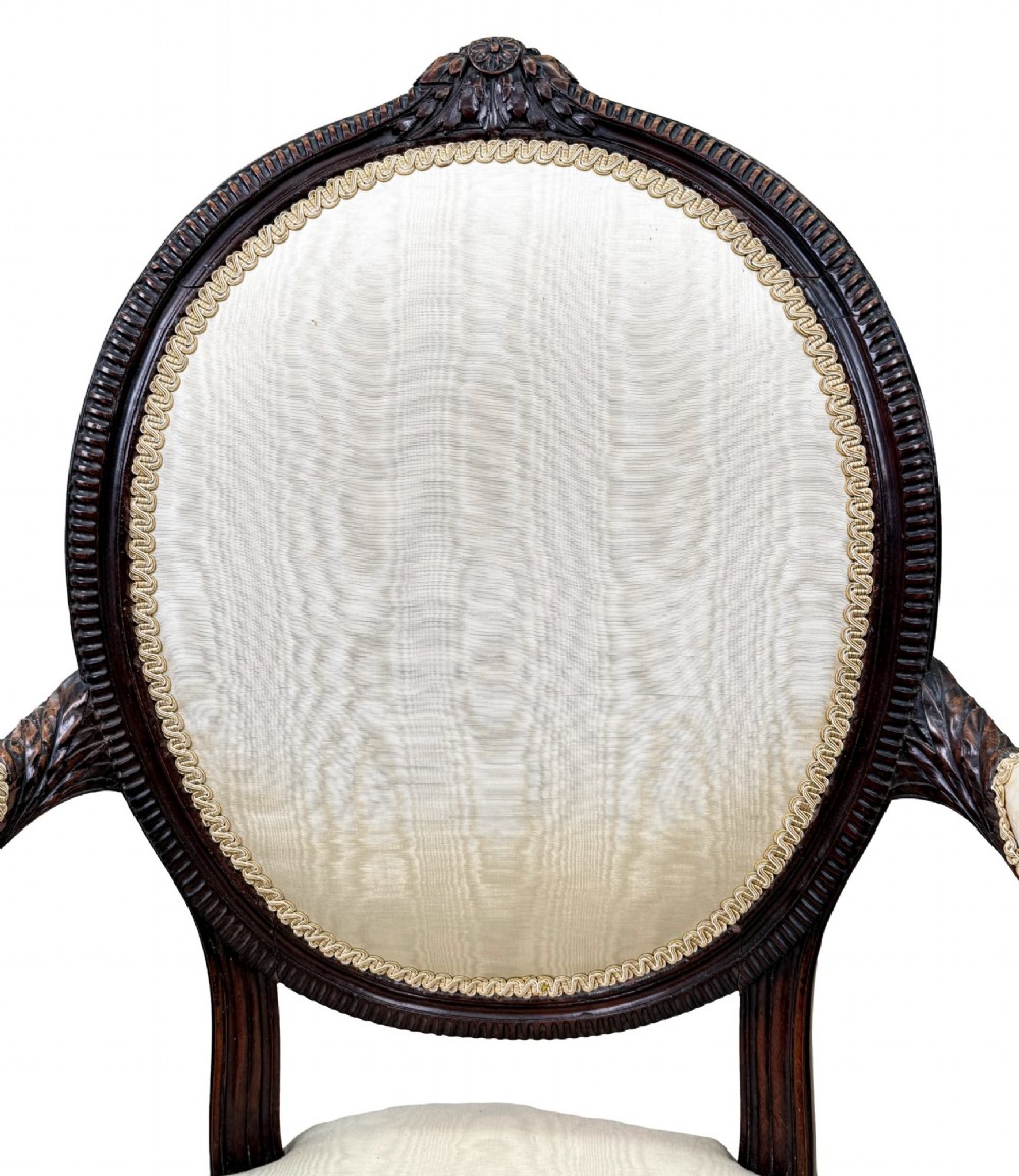 An 18th-century Georgian mahogany salon chair featuring an oval back rest, carved wooden frame, and cream silk upholstery. View IV