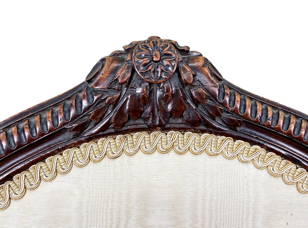 An 18th-century Georgian mahogany salon chair featuring an oval back rest, carved wooden frame, and cream silk upholstery. View VII
