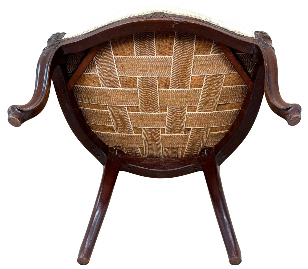 An 18th-century Georgian mahogany salon chair featuring an oval back rest, carved wooden frame, and cream silk upholstery. View XIII