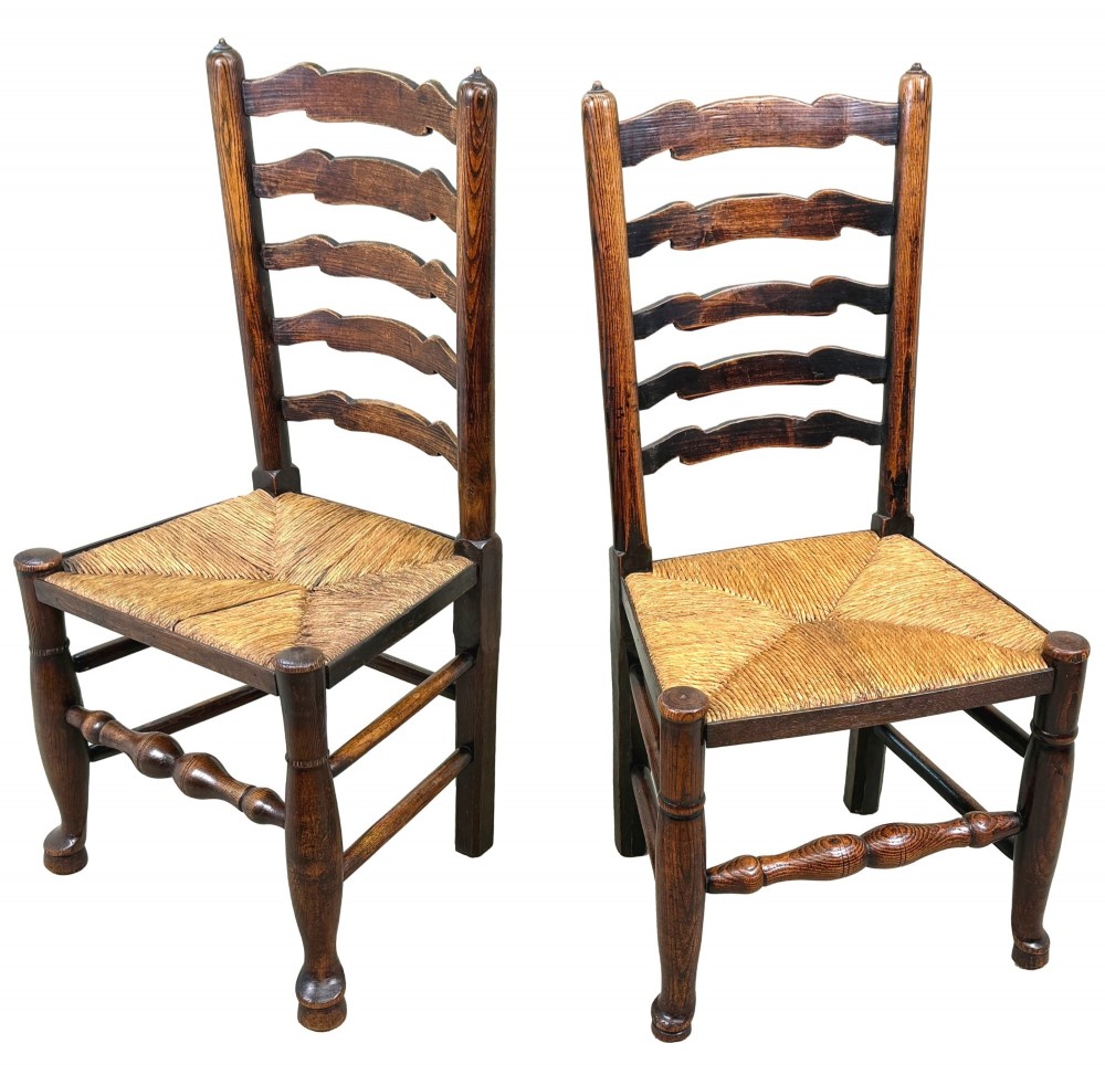 A set of ten early 19th-century Georgian country dining chairs featuring waved ladderback slats, woven rush seats, and turned wooden legs. View V
