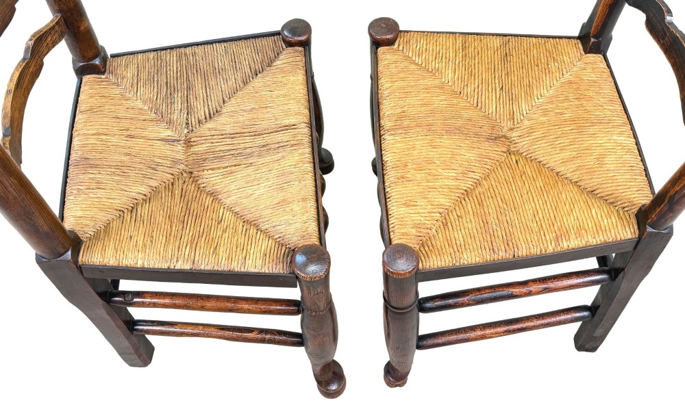 A set of ten early 19th-century Georgian country dining chairs featuring waved ladderback slats, woven rush seats, and turned wooden legs. View VI