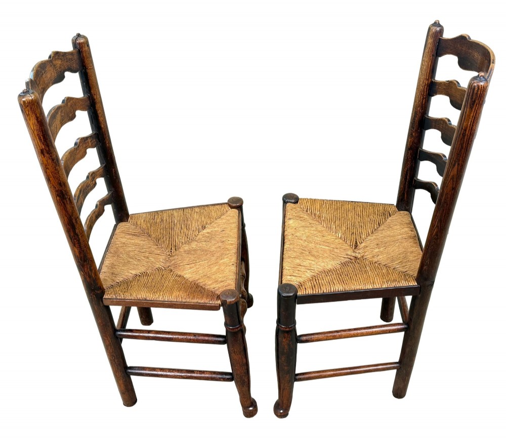 A set of ten early 19th-century Georgian country dining chairs featuring waved ladderback slats, woven rush seats, and turned wooden legs. View IX