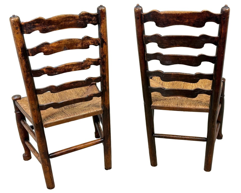 A set of ten early 19th-century Georgian country dining chairs featuring waved ladderback slats, woven rush seats, and turned wooden legs. View X