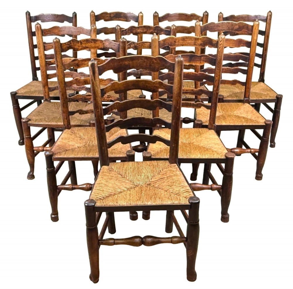 A set of ten early 19th-century Georgian country dining chairs featuring waved ladderback slats, woven rush seats, and turned wooden legs. View XIII