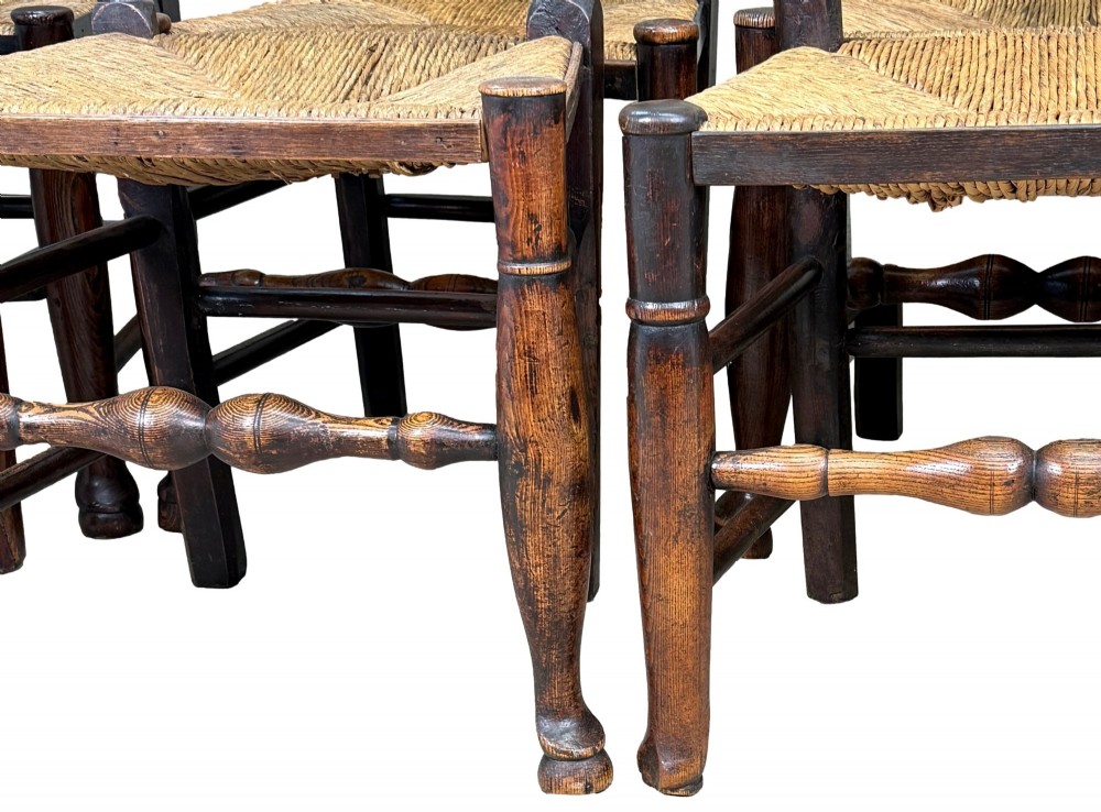 A set of ten early 19th-century Georgian country dining chairs featuring waved ladderback slats, woven rush seats, and turned wooden legs. View XV