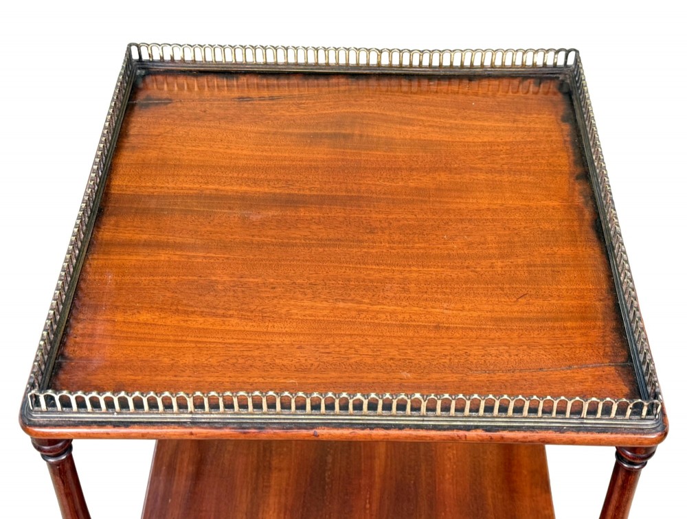 A three-tier Regency mahogany whatnot featuring a pierced brass gallery top rail, turned support columns, and brass castors. View II