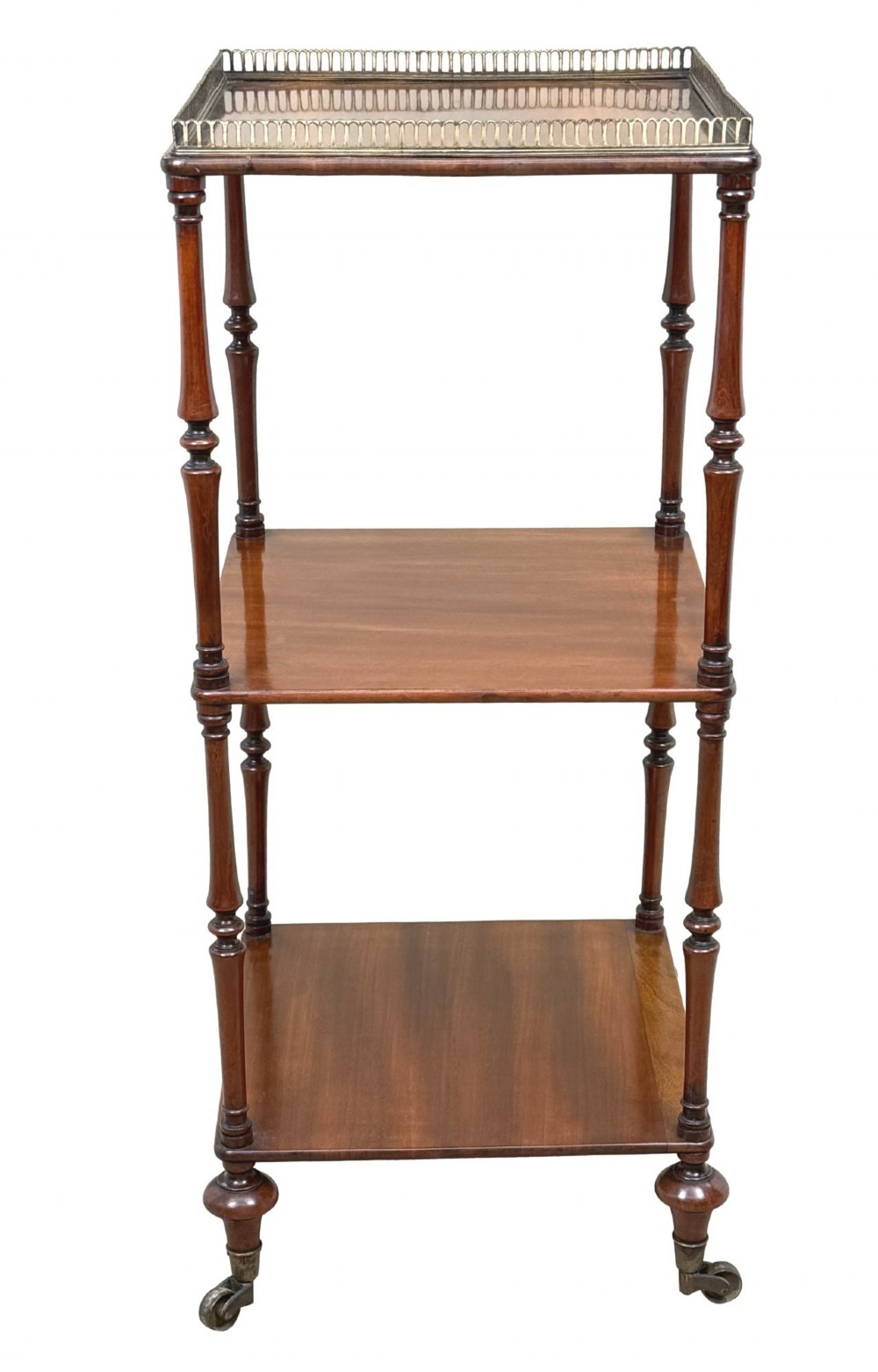 A three-tier Regency mahogany whatnot featuring a pierced brass gallery top rail, turned support columns, and brass castors. View III