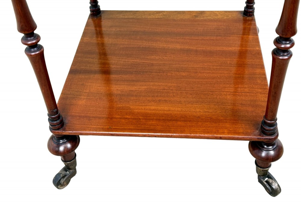 A three-tier Regency mahogany whatnot featuring a pierced brass gallery top rail, turned support columns, and brass castors. View VI