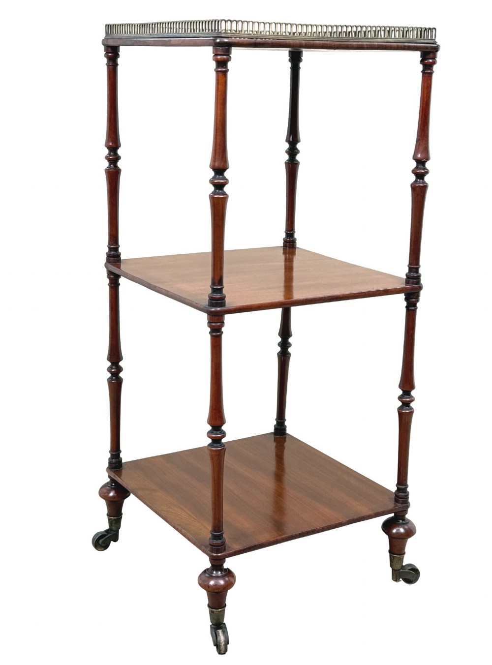 A three-tier Regency mahogany whatnot featuring a pierced brass gallery top rail, turned support columns, and brass castors. View VII