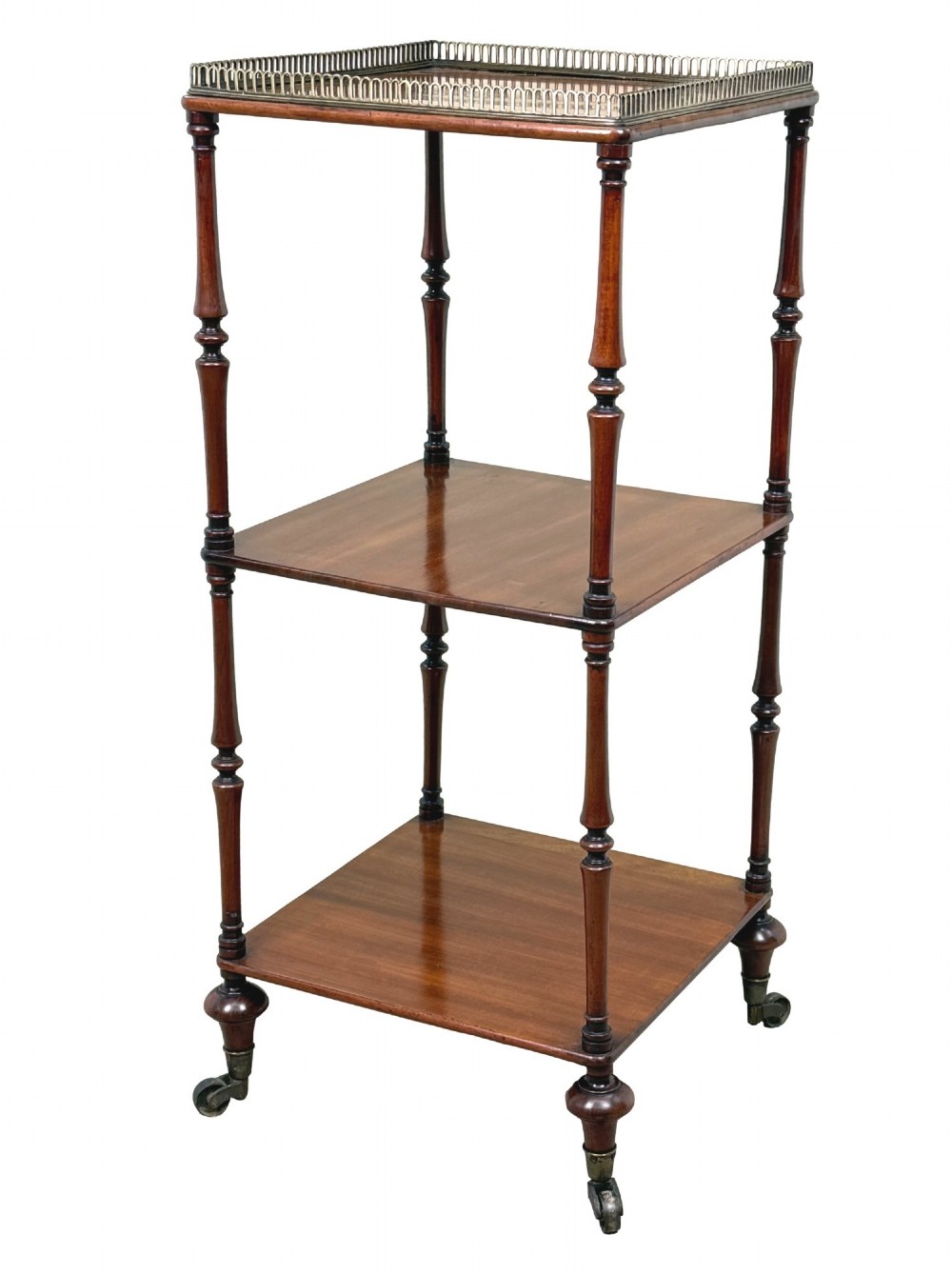 A three-tier Regency mahogany whatnot featuring a pierced brass gallery top rail, turned support columns, and brass castors. View IX