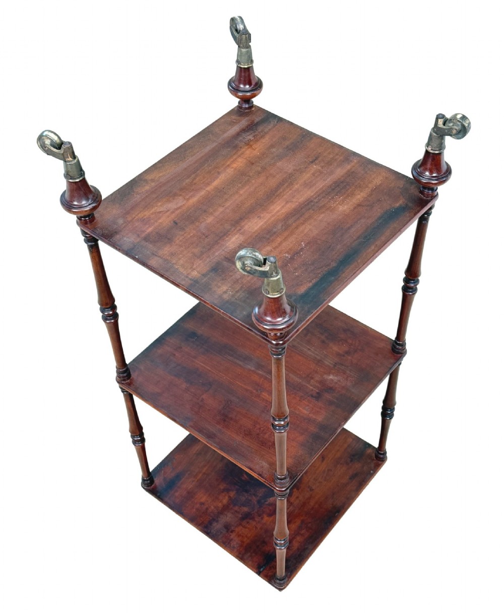 A three-tier Regency mahogany whatnot featuring a pierced brass gallery top rail, turned support columns, and brass castors. View XIV