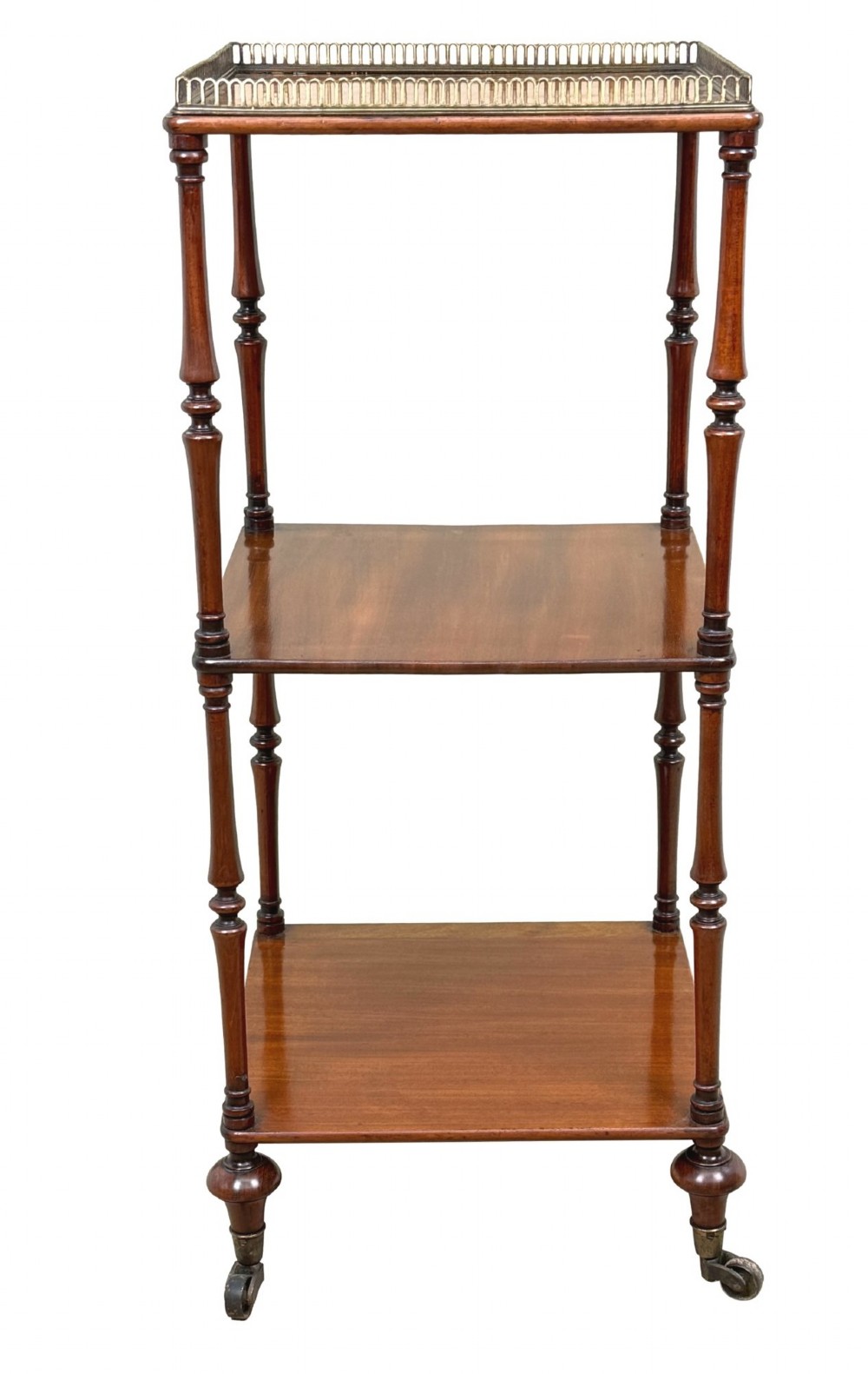 A three-tier Regency mahogany whatnot featuring a pierced brass gallery top rail, turned support columns, and brass castors. View XV